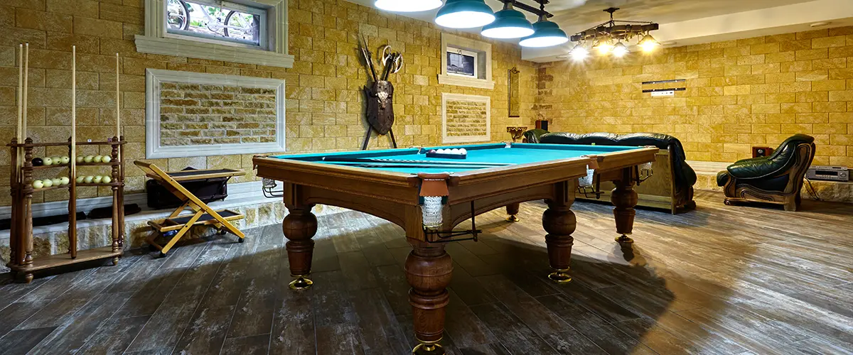 A basement transformed into a game room with a pool table