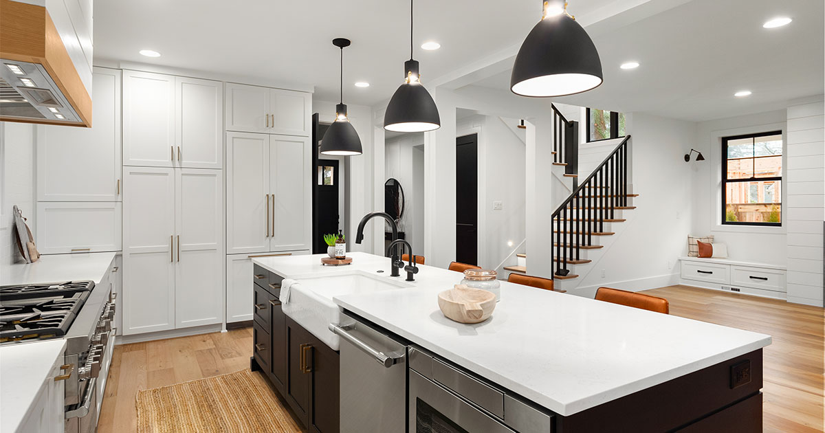 A quartz kitchen island with dark cabinets in a room with white kitchen cabinets
