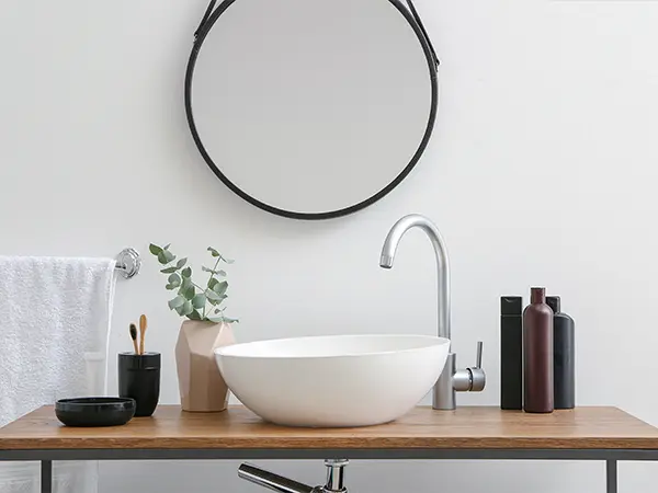 A vessel sink with a black mirror frame