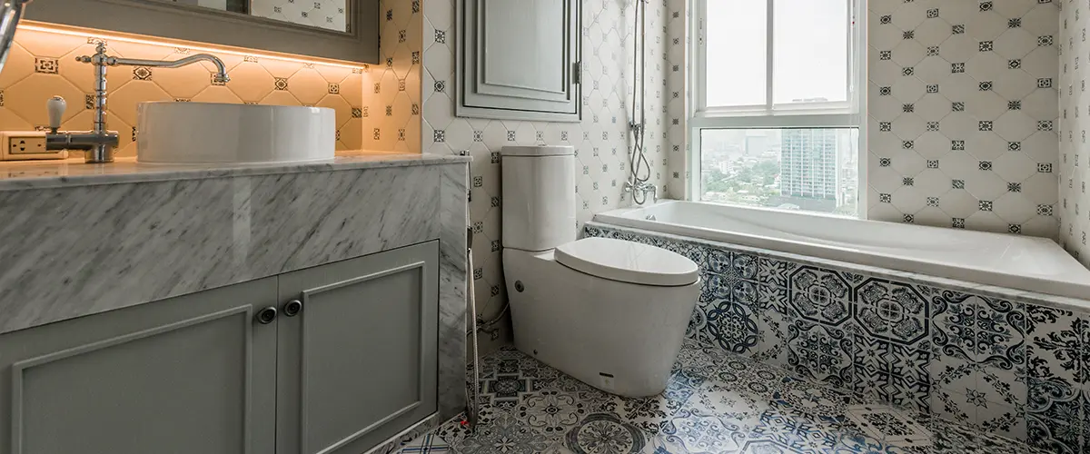 A beautiful bathroom with decorative tile and gray vanity