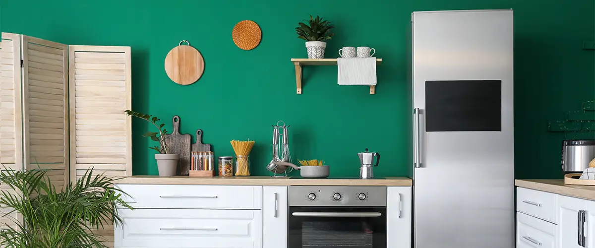 Green walls in a kitchen with white cabinets