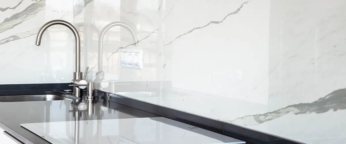 Marble backsplash with a silver faucet and drop-in sink