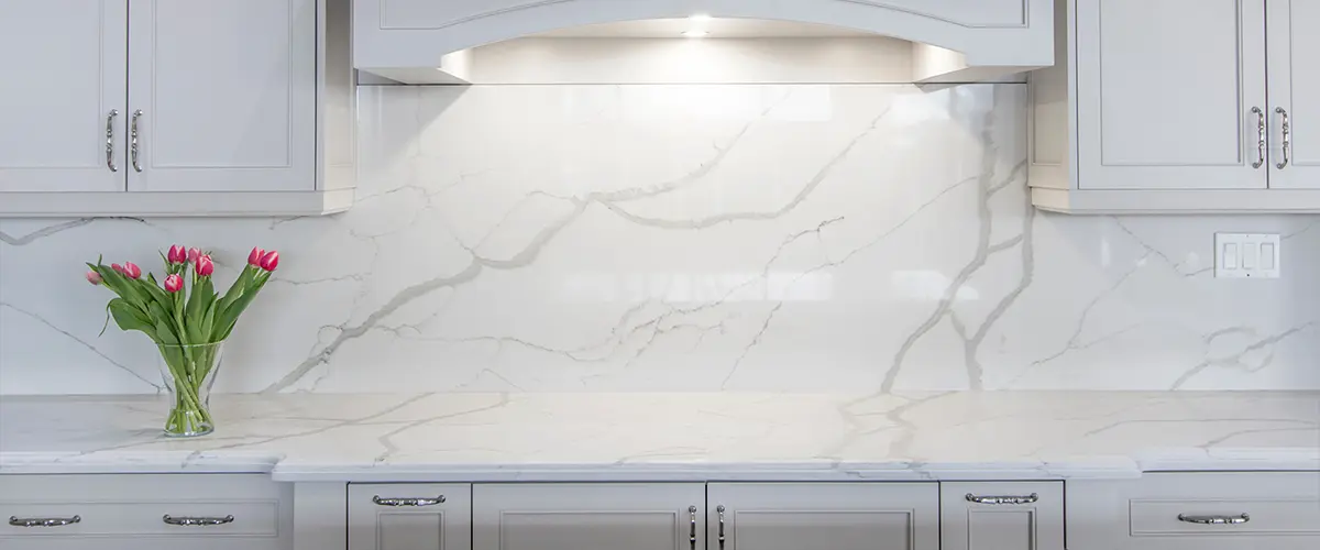 A quartz countertop with off-white cabinets
