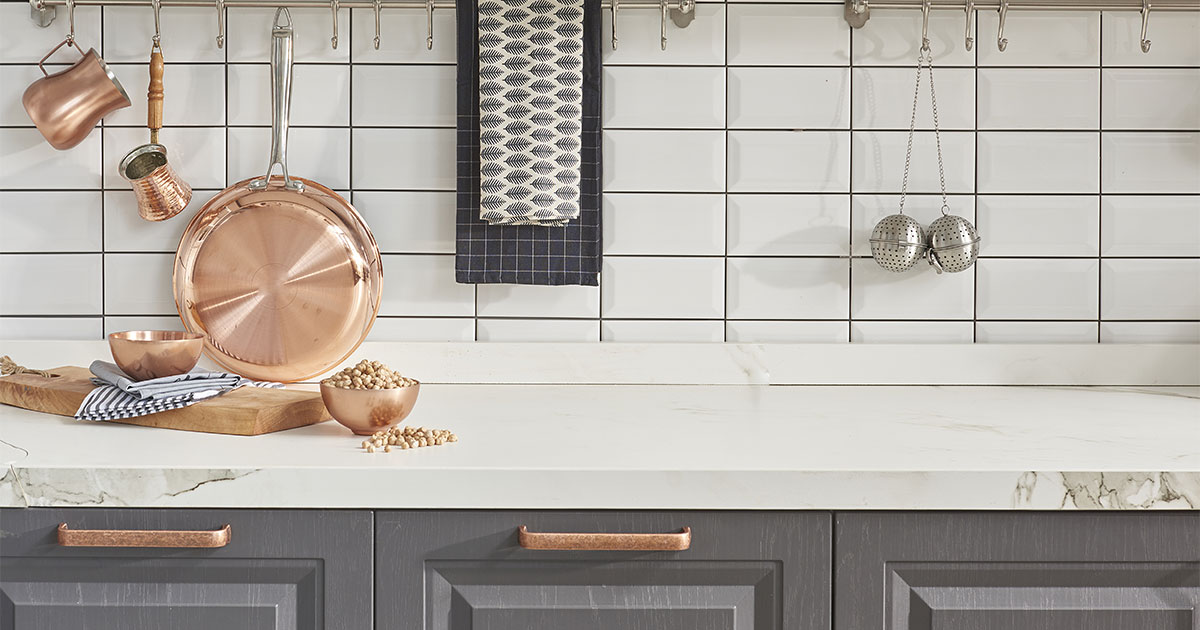 A kitchen countertop material with what looks like copper kitchen hardware
