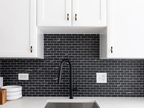 Black tile backsplash with white cabinets