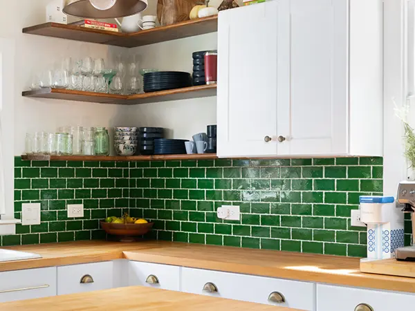 Green tile backsplash with butcher block countertops