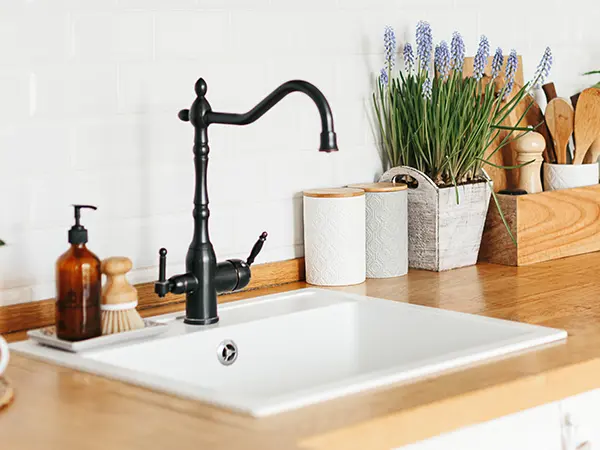 A drop-in sink with dark faucet