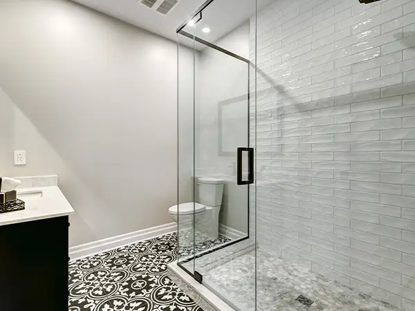 Large shower with beautiful tile flooring and black accent colors