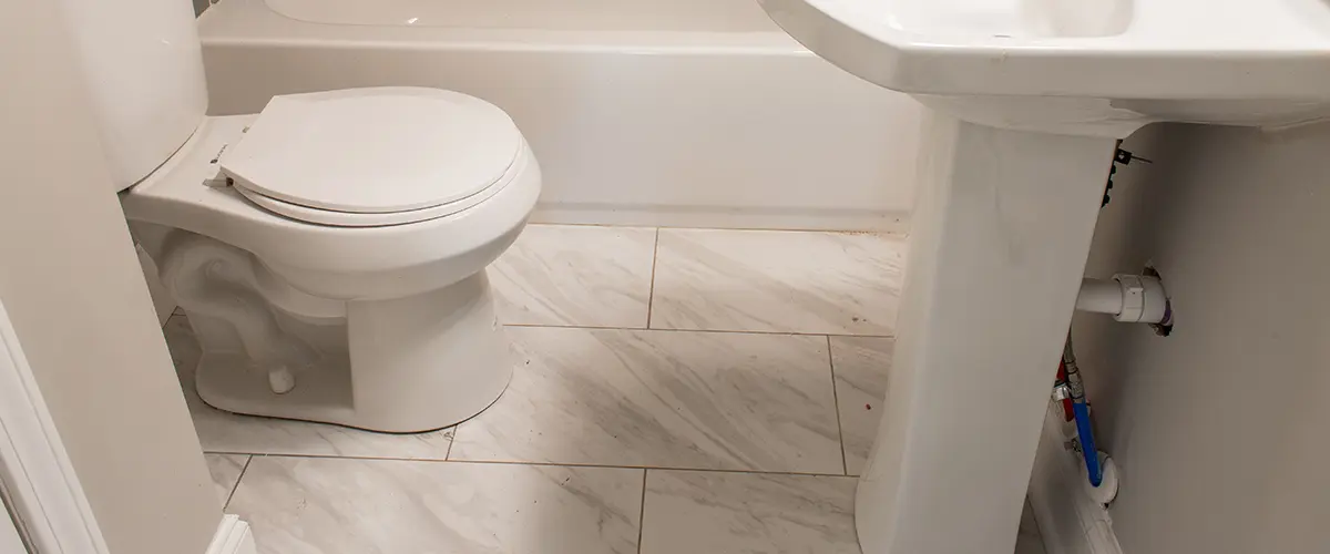 Large tile flooring in a basic, small bathroom