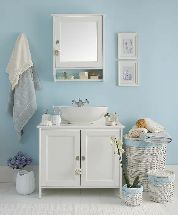 Blue walls with a simple vanity and a cabinet above it