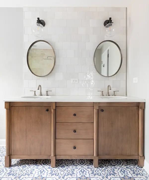 A double wood vanity with two round mirrors and black hardware