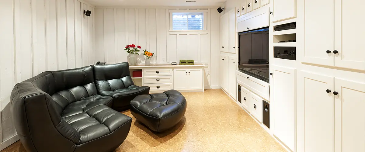 A living space in a basement with a dark leather couch